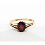 9ct gold ring set with a single oval mixed cut almandine garnet with pierced shoulders