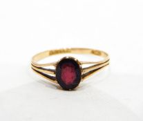 9ct gold ring set with a single oval mixed cut almandine garnet with pierced shoulders