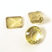 Circular cut citrine loose stone with faceted underside and two rectangular cut citrines,