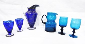 Blue glass water set comprising pedestal jug and set of four pedestal glasses,