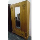 Edwardian wardrobe with bevelled mirror panelled door and with carved ornamentation and drawer to