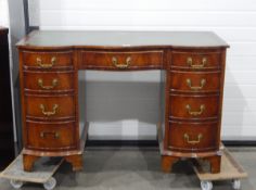 Serpentine-fronted reproduction mahogany kneehole desk, the top inset with green and gilt leather,