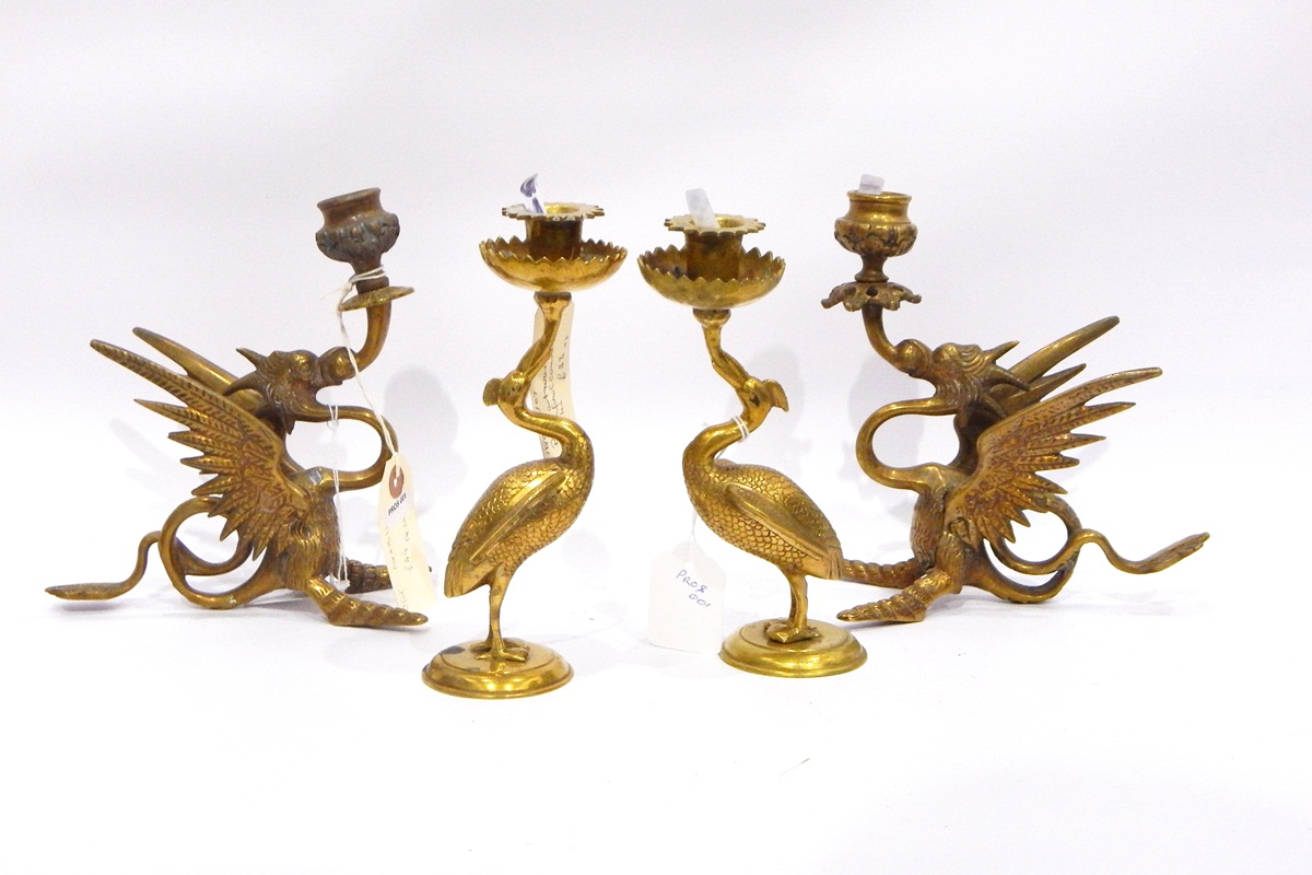 Pair of brass crane-pattern candle holders, each on circular base,