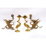 Pair of brass crane-pattern candle holders, each on circular base,