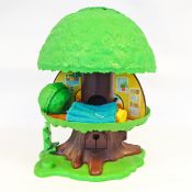 Two soft plastic dolls and a Fisher Price tree house with accessories