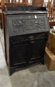 Victorian ebonised and carved bureau, with open shelf top, the fall enclosing pigeonholes,