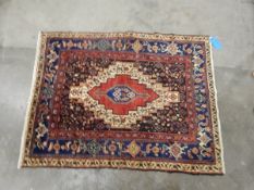 Eastern wool rug with stepped cream and ruby arabesque to the midnight blue field,