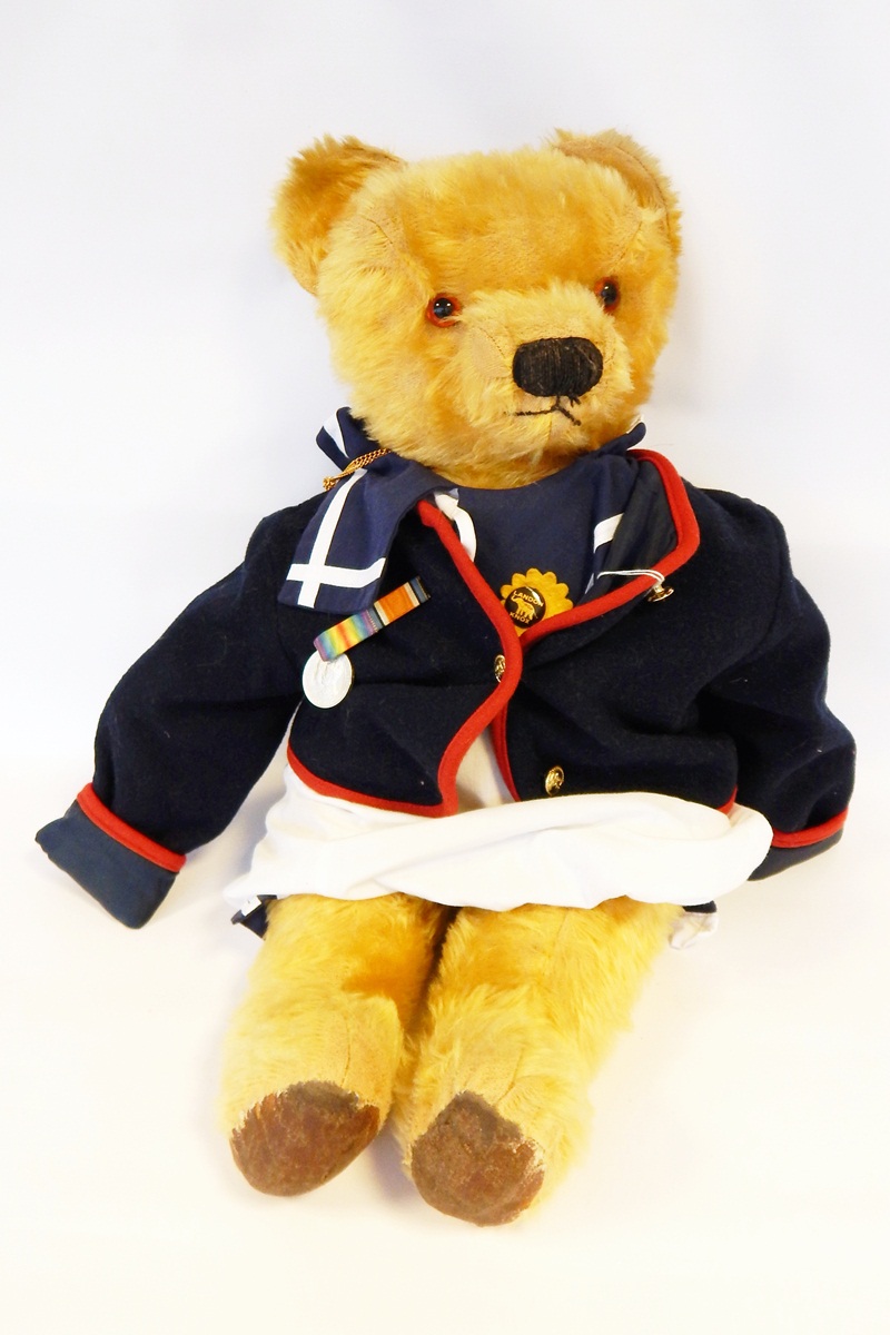 Large gold plush bear wearing a sailor suit and a jacket with bell and medal,