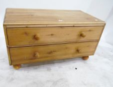 Pine chest of two long drawers on bun feet,