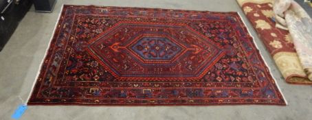 Eastern wool rug of Caucasian-style with blue hexagonal arabesque to centre of midnight blue field,