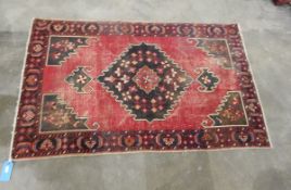 Eastern wool rug with octagonal stepped gul to centre of cherry red field,