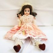Early 20th century 'Flora Dora' doll with brown ringlets, pink silky and lace dress, suede boots,