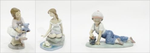 Lladro figurine of seated girl with teddy bear, a boy with train,