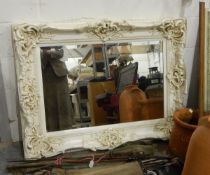 Large mirror in an elaborately carved wooden frame, painted cream,