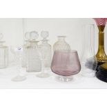 Three strawberry cut square-shaped decanters, a pair of tapering cut bottles lacking stopper,