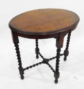 An oak oval top occasional table, on spiral supports,