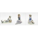 Lladro porcelain figures of three seated children, the girls with flowers,