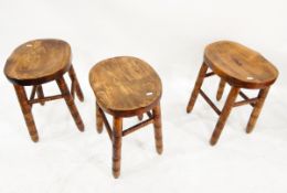 Three elm seated stools on turned supports and stretchers