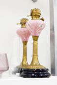 Pair of Victorian oil lamps, opaque glass reservoirs with pink trailed decoration,