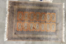 Pakistan wool rug in two rows of seven rectangular guls on an apricot field