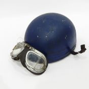 Vintage motorcycle helmet with the logo of a flying eagle and a pair of vintage motorcycle goggles