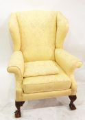 Upholstered wing side easy chair on squat carved cabriole supports with claw and ball feet