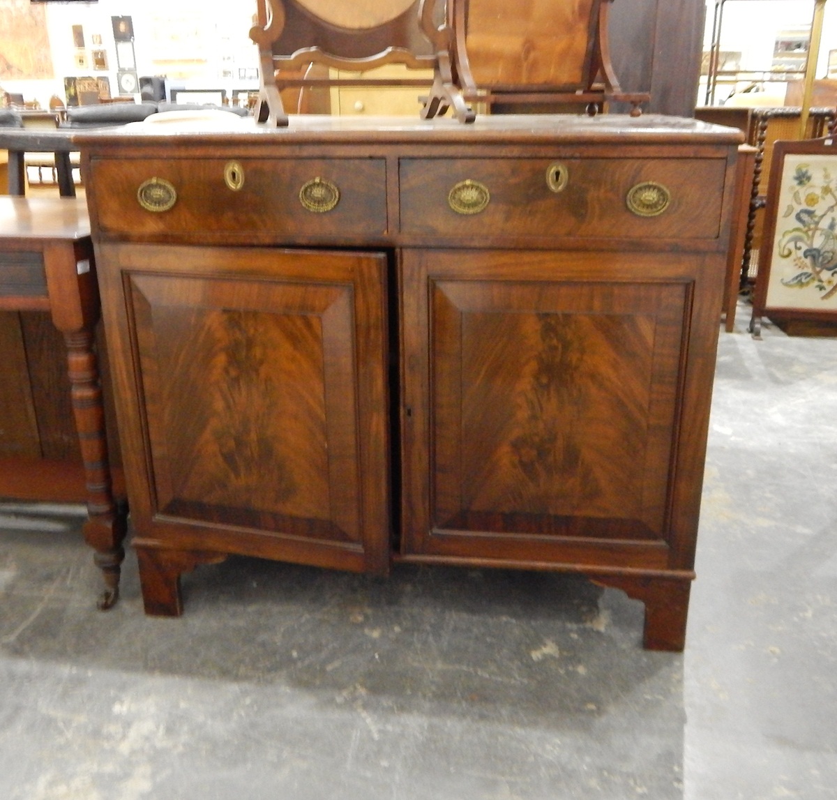 19th century dwarf mahogany side cabinet having two drawers over two field panelled doors,