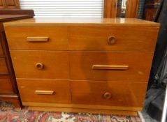 Polished solid wood chest of six short drawers, three of which have turned knob handles,