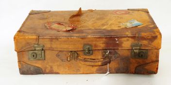 Vintage leather suitcase with various shipping labels,