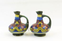 Pair Dutch R Hodian pottery ewers, each decorated with blue, yellow,
