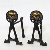 Pair of Art Nouveau-style black painted metal fire dogs decorated with brass hearts in relief