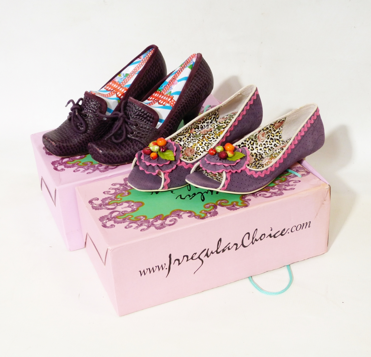 Two pairs of Irregular Choice ladies shoes, one faux purple crocodile skin the other purple leather,