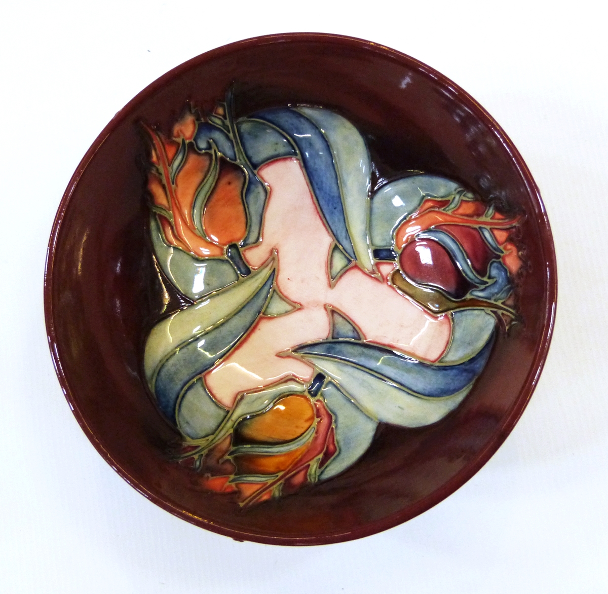 Modern Moorcroft pottery bowl, stylised tulip decorated, on a burgundy coloured ground,