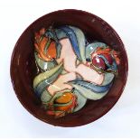 Modern Moorcroft pottery bowl, stylised tulip decorated, on a burgundy coloured ground,