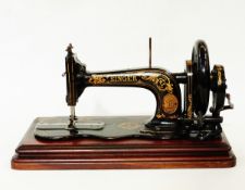 Victorian Singer sewing machine with gilt decoration on black ground,