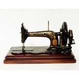 Victorian Singer sewing machine with gilt decoration on black ground,