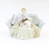 Naples porcelain figure of 19th century lady seated on sofa wearing bonnet,