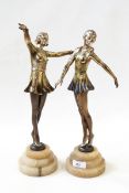 Two 1920's bronze-effect spelter dancing girls, each on circular stepped alabaster base, 35.