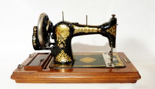 Jones's sewing machine decorated with gilt scrolling foliate design on a black ground,