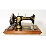 Jones's sewing machine decorated with gilt scrolling foliate design on a black ground,