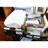 Various tablecloths and embroidered table linen including a large white tablecloth,