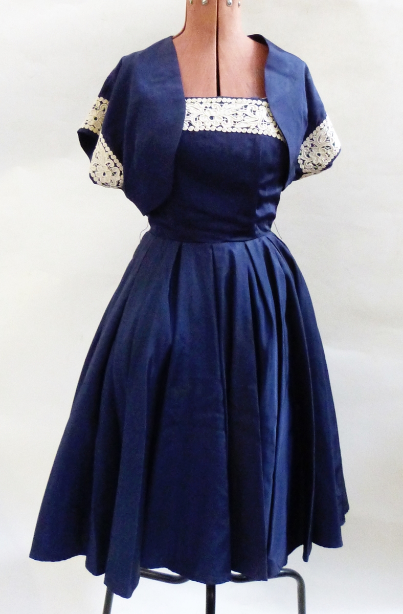 Blue satin 1950's cocktail gown, the bodice trimmed with lace and a bolero top,