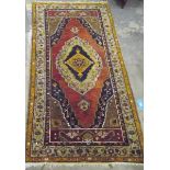 Eastern wool rug, with central flowerhead medallion on a red field within multiple floral borders,