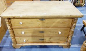 Old pine chest of three drawers flanked by turned split pilasters and on bracket feet,