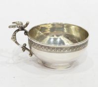 White metal cup of shallow circular form, decorated with a band of anthemion,