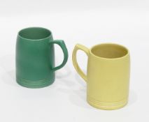 Two Wedgwood Keith Murray mugs in yellow matt glaze and green matt glaze, of ribbed based form,