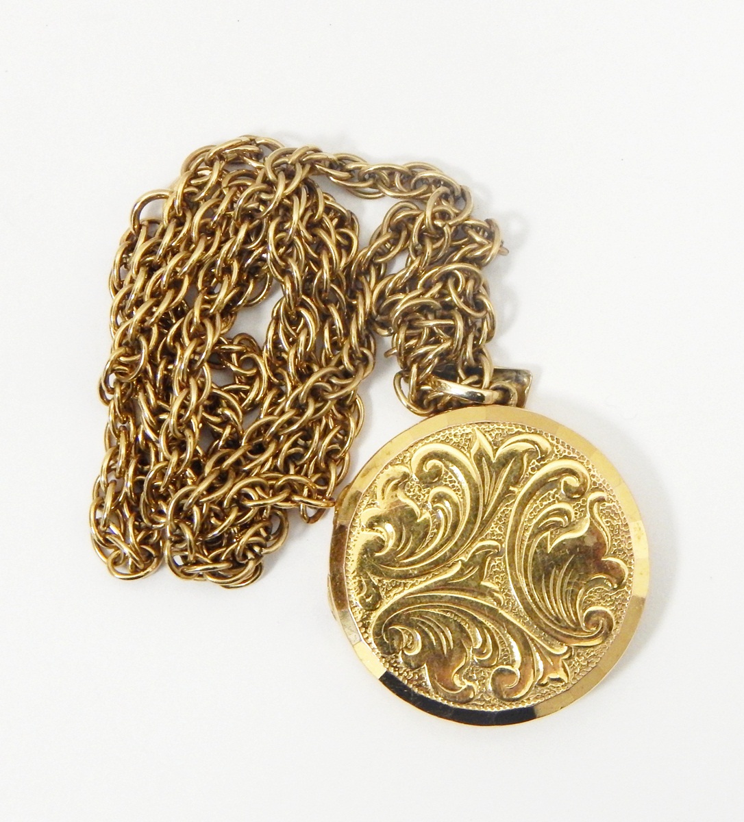 9ct gold locket of circular form with foliate decoration,