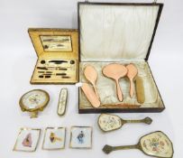 Cased dressing table set with peach enamel backs and gilt metal borders, a cased manicure set,