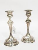 Pair of George V silver table candlesticks, each with thistle-pattern sconce,