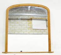 Overmantel mirror of rectangular form with arched top, the frame with ebonised and gilt decoration,